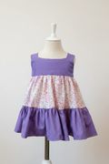 Toddler purple polka dot tiered dress on a dress form with a clean neutral background