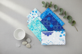 Siena Blue fat quarter bundle fanned out in a calm elegant setting with soft blue and aqua fabrics