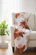 Big Island Blooms Quilt Pattern lifestyle photo — modern curved petal quilt draped over white linen armchair with tropical plant